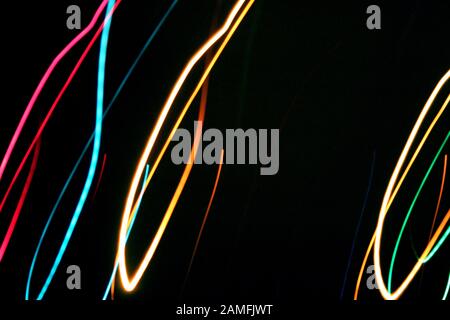 Multicolored color lines light painting of fire in the dark. Close up on black night background view. Text copy space. Celebration holiday concept Stock Photo
