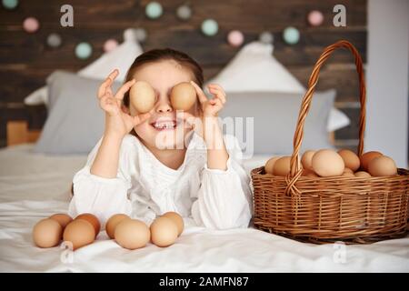 Girl holding eggs in front of her eyes Stock Photo