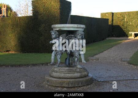 Three Cherub sundial located in the gardens of Polesden Lacey, a National Trust site in Great Bookham, Surrey, England, UK, January 2020 Stock Photo