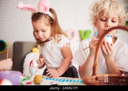 Handmade easter eggs painted by siblings Stock Photo