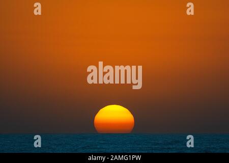 Colourful sunrise over the Pacific Ocean  on a hazy morning. Stock Photo