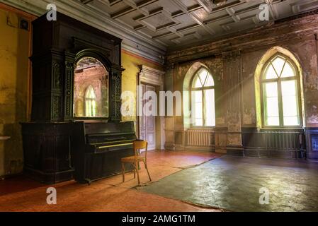 Piano in the hall of abandoned Sharovskiy castle or Sharovka, Kharkov region Stock Photo