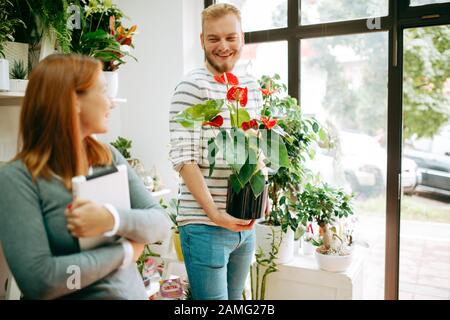 Young smiling people florists working in the home Stock Photo