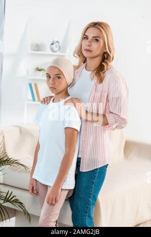 upset mother standing near sick daughter at home Stock Photo