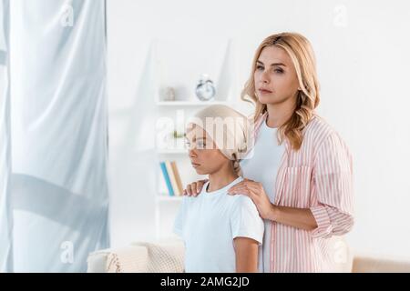sad mother standing near sick daughter at home Stock Photo