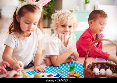 Happy kids start decorating easter eggs Stock Photo