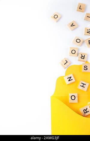 Text, message, letters scattered in yellow envelope isolated on white background. Stock Photo