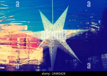 Paper star on the window with reflection Stock Photo