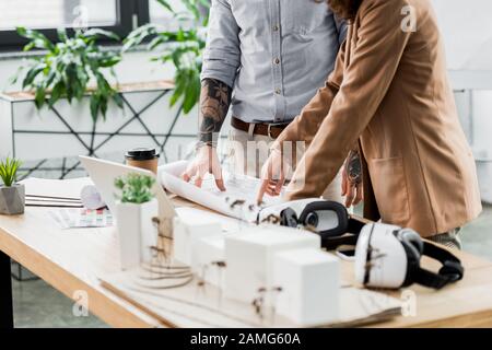 cropped view of virtual reality architects looking and pointing with finger at blueprint Stock Photo