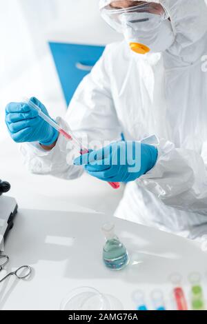 cropped view of scientist in protective suit and latex gloves doing dna test Stock Photo