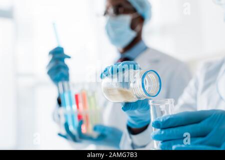 selective focus of multicultural biologists doing test in lab Stock Photo