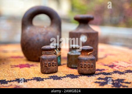 Closeup of rusty metal weights of various shapes and weights close up on a blurred background Stock Photo