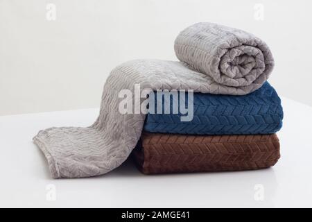 stack of folded soft blankets on the white table Stock Photo