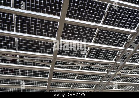 Close-up of solar panels in an array atop a parking lot in San Ramon, California, November 21, 2019. Many real estate developers are integrating solar arrays into designs for new parking lots, to provide shade while obtaining low-cost electrical power. () Stock Photo