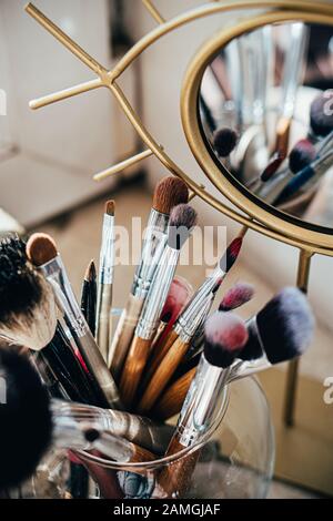 Many different makeup brushes in artist's studio with mirror reflection Stock Photo