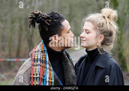 Young intercultural and happy student couple during a winter walk in Bottrop, Germany. Stock Photo