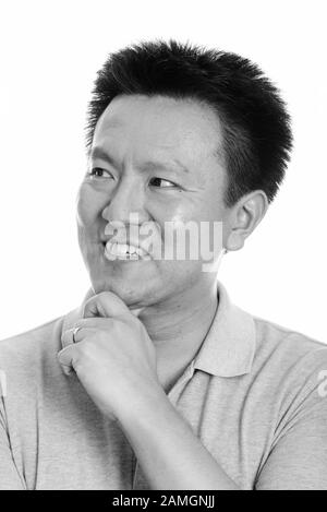 Face of happy Japanese man smiling while thinking Stock Photo