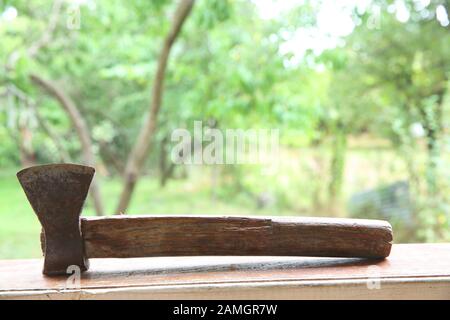old axe on wooden table . Ax on a wooden board green background . Stock Photo