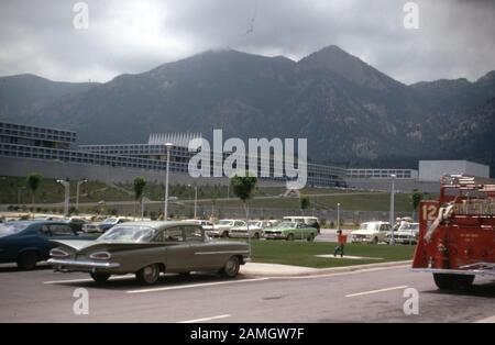 Cars are parked outside the United States Air Force Academy, with top of Cadet Chapel visible in background, Colorado Springs, Colorado, 1970. () Stock Photo