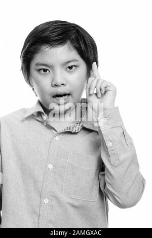 Studio shot of cute Japanese boy pointing finger up Stock Photo