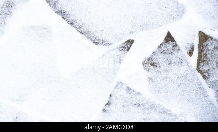 Winter pavement background. Snow covered wild stone paving tiles Stock Photo