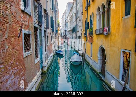 Venice sunset cityscape, boats, water canal, double bridge and traditional buildings. Italy, Europe. Stock Photo