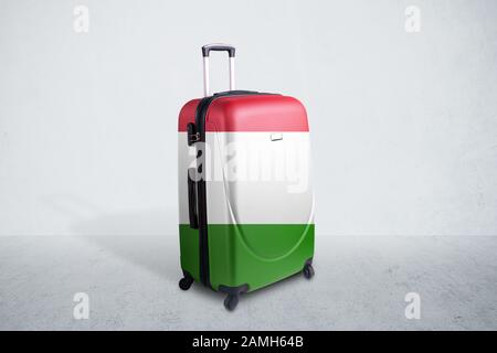 Travel suitcase with the flag of Italy. Holiday destination, suitcase over concrete room background Stock Photo