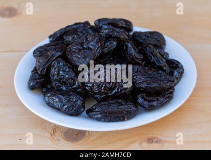 Tasty dried plums on wooden background close up Stock Photo