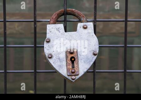 hanged old padlock on a fence of a bridge for love Stock Photo