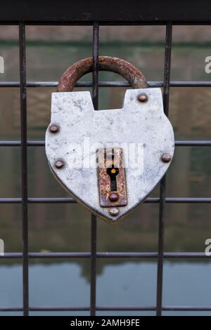hanged old padlock on a fence of a bridge for love Stock Photo