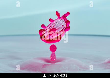 High speed water drop photograph with red colored colliding drops Stock Photo