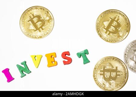 Invest word letterboard with golden bitcoin on white background. Invest in bitcoin concept Stock Photo