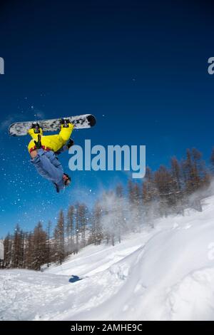 Snowboarder performing trick in snow park Stock Photo