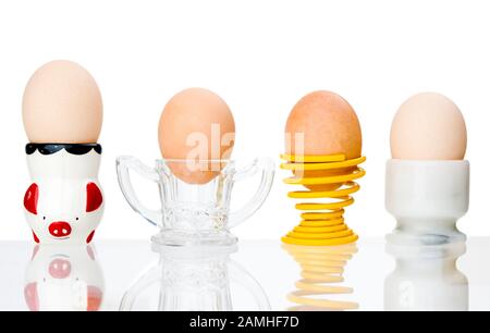 Four Eggs in a variety of different eggcups in a row Stock Photo