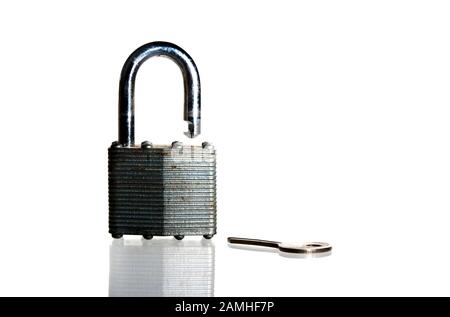 Unlocked old padlock with the key beside it - studio shot on white background Stock Photo