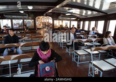 Hong Kong star ferry interior - passengers inside the cabin of a Star Ferry on it's route across the harbour, Hong Kong Asia Stock Photo