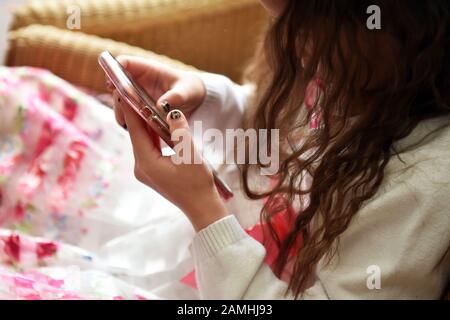 Young girl plays on her mobile phone at a party. Stock Photo