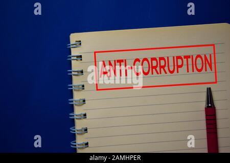 Anti-Corruption write on a book isolated on blue background. Stock Photo