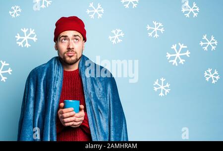 Boy caught a cold and drinks hot the. Cyan background. Concept of illness Stock Photo