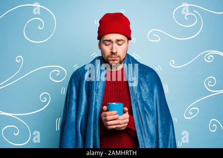 Boy caught a cold and drinks hot the. Cyan background. Concept of illness Stock Photo