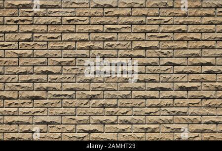 Decorative wall texture, background. Stone cladding of matted stone bricks regular form in soft beige color. The fragment of a new decorative stone Stock Photo