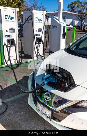 A Nissan is charging at a Charge Point charge station the street on ...