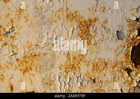 The wall is white with cracked paint, rusty metal and bullet holes. Creative vintage background Stock Photo