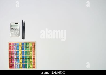 Multiplication table . Macro mode. Colored wooden cubes. Teaching children math and numeracy. Mental math. Calculator and pens, copy space Stock Photo