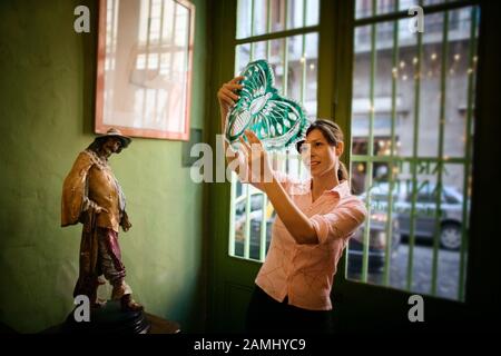 A woman thoughtfully looks at a decorative piece. Stock Photo
