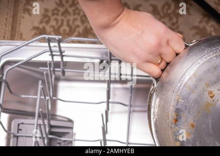 Loading dishes in the dishwasher, gray mesh dishwasher. Selective focus Stock Photo