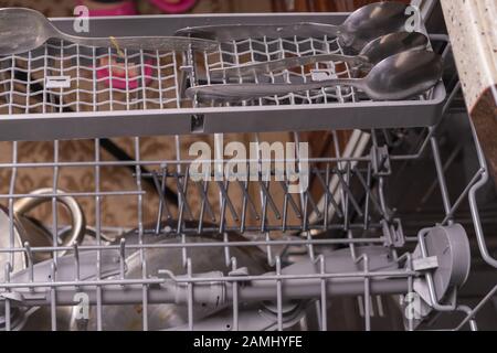 Loading dishes in the dishwasher, gray mesh dishwasher. Selective focus Stock Photo