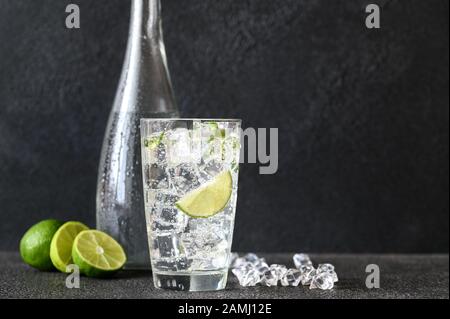 Glass of sparkling water with ice cubes and slice of lime Stock Photo