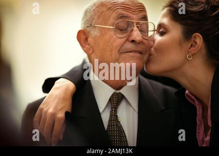View of a woman kissing a senior man. Stock Photo