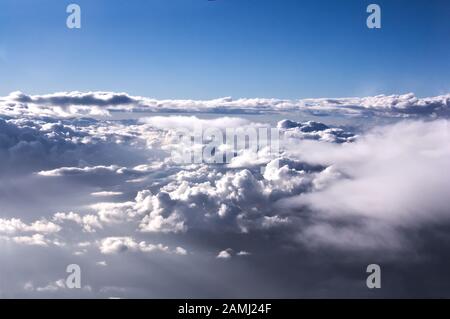 Sea of clouds seen from a plane, in the background you can see the blue sky, completely clear Stock Photo